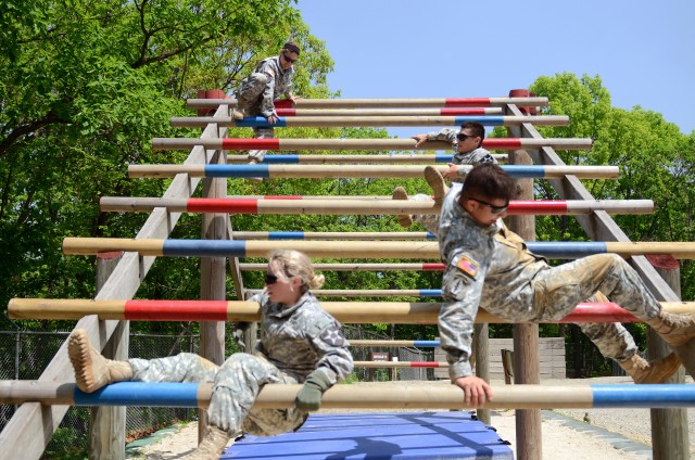 Soldiers on the Sheepdog team of the 1st Brigade Support Battalion, 1st Armored Brigade Combat Team, 2nd Infantry Division, traverse the weaver on the Camp Hovey Air Assault Obstacle Course during the
