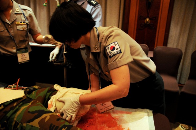Maj. Han Ja-Gyeong, Republic of Korea Army, bandages an