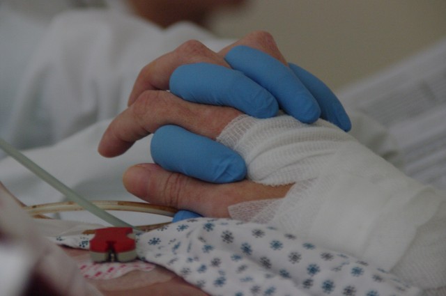 Nurse holds the hand of a patient