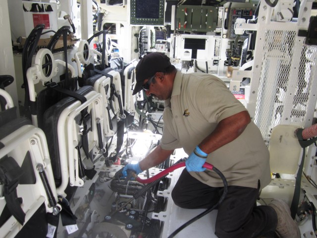 401st AFSB employee washes inside of Stryker