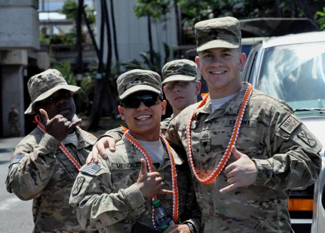 Redeployed Alpha Company, 307th Expeditionary Signal Battalion Soldiers flash shaka signs at Honolulu International Airport