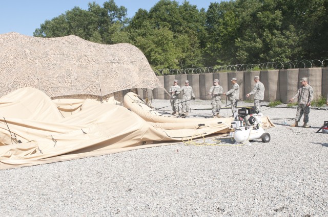 Soldiers set up an air-supported tent 