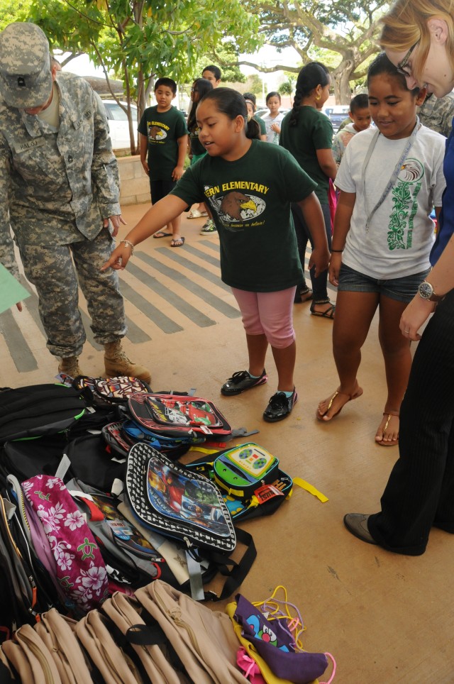 Soldiers and Civilians of HHC, 311th SC (T) help students chose a backpack among the colorful array of donated school supplies, presented to Fern Elementary School, Sep. 10.