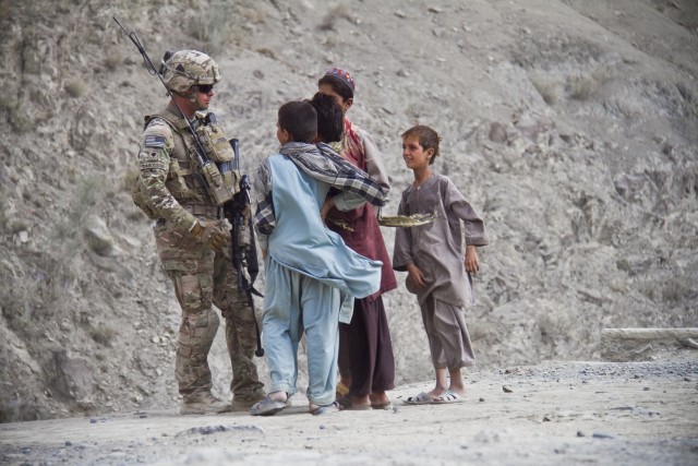 U.S. Army Spc. Larousse speaks with Afghan children