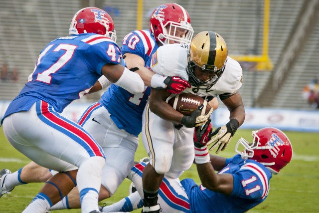 Army running back Terry Baggett plows through three defensive players