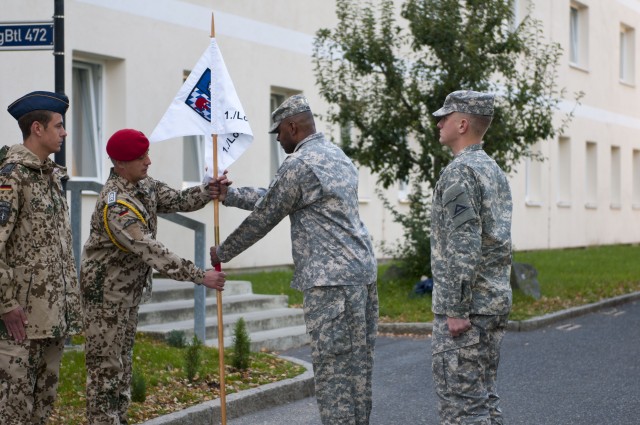 Command Sgt. Maj. David Benning passes the guidon