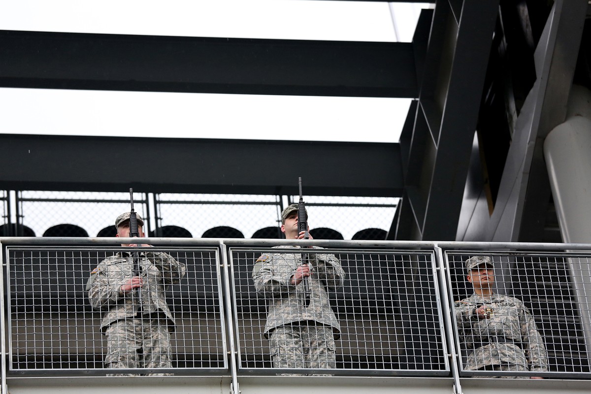 Service members from all five branches of the armed services carry a large  American flag out onto the field at the Salute to Service Chicago Bears  game Nov. 27 at Soldier Field