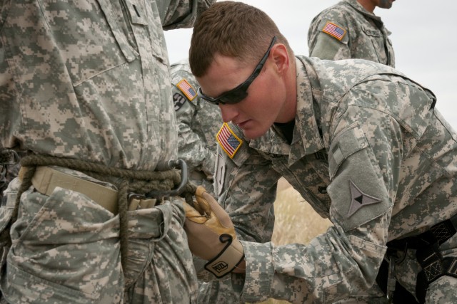 Air Assault School instructor inspects student's harness