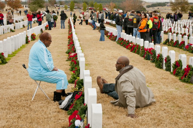 Family members place Christmas wreaths on graves of fallen heroes