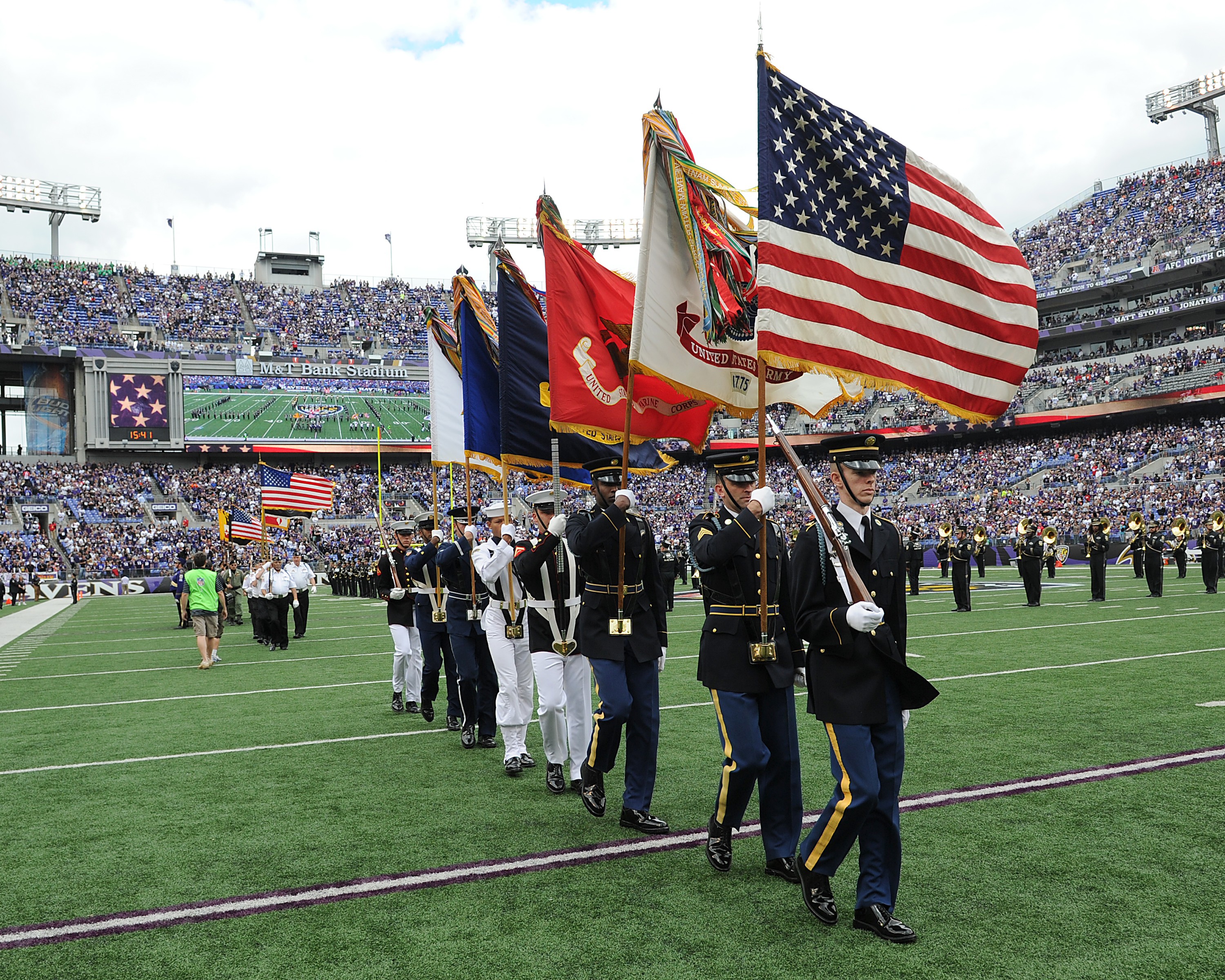 Military personnel carry the colors before the start of an NFL