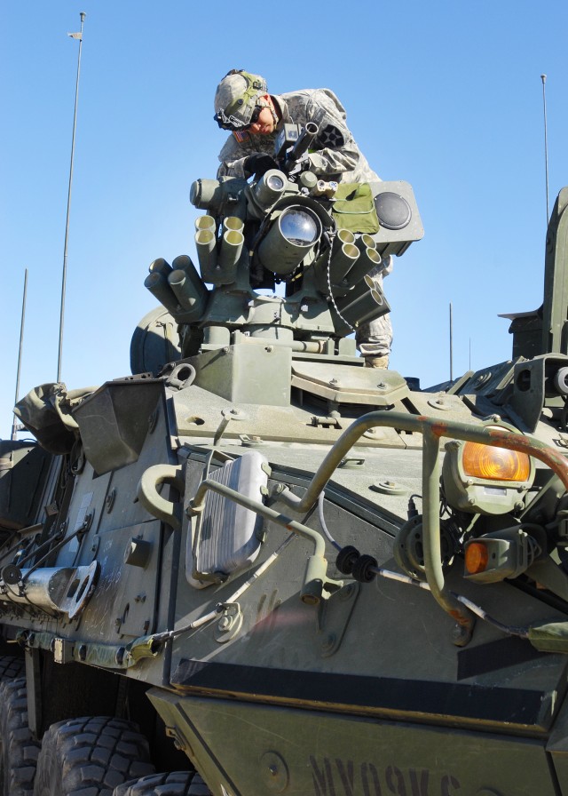 Sgt. Gilbert Salapuddin installs MILES equipment on Stryker vehicle