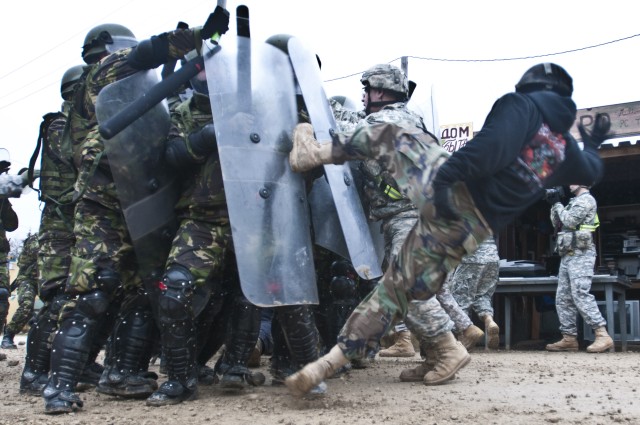 Rioter kicks a shield at JMRC