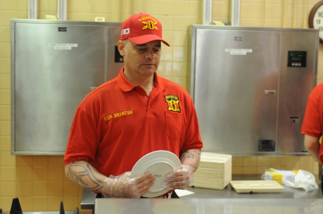 Command Sgt. Maj. Brinton serves chow to Soldiers