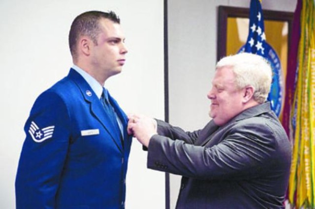Air Force Staff Sgt. Steven Doty, a master instructor at the Defense Information School, is awarded The Soldier's Medal by his father, retired Air Force Lt. Col. Timothy Doty, in a ceremony Friday at
