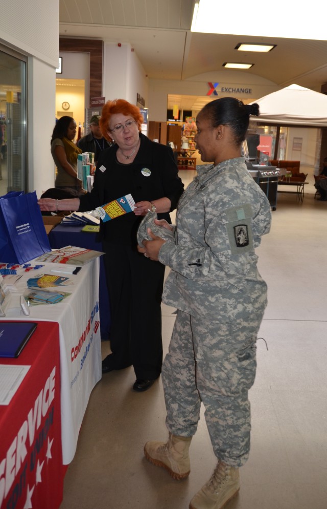 A soldier looks for information from a bank representative.