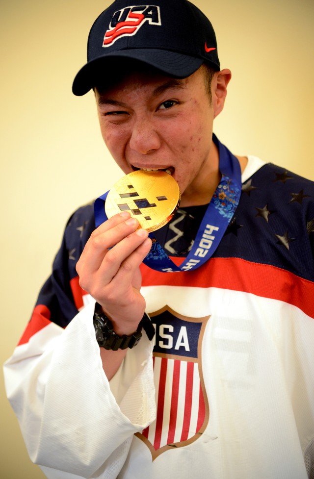 Staff Sgt. Jen Lee bites Paralympic gold medal