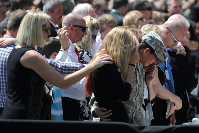 Family and friends of victims listen to taps during Fort Hood Memorial Ceremony