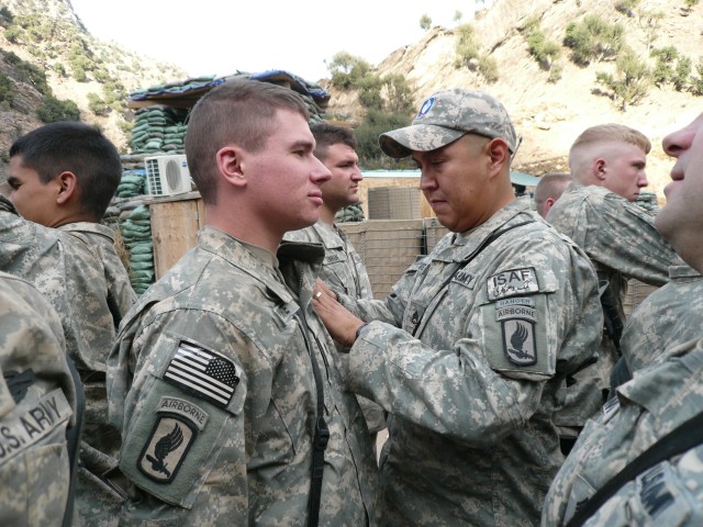 Staff Sgt. Conrad Begaye awards Spc. Kyle White the CIB