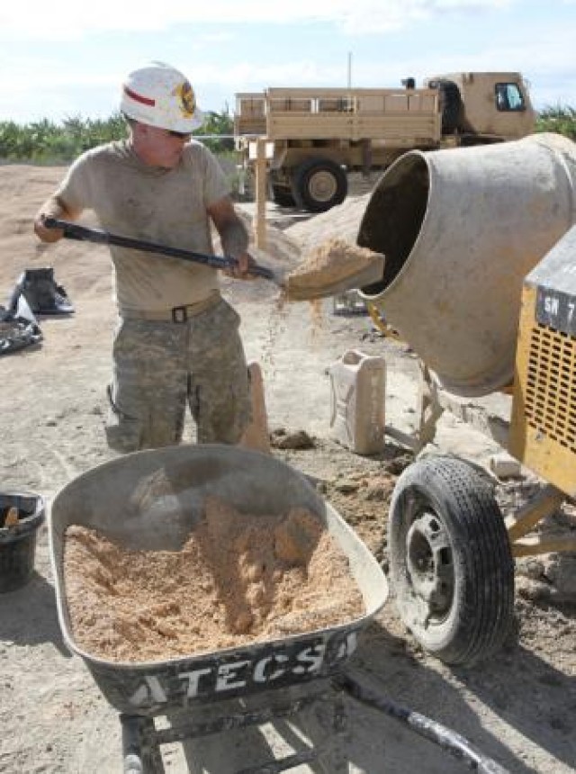 Solider mixes concrete for a new school