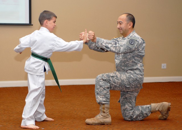 Alexander Ziegler hits board held by Col. Todd Kimura, commander of United States Army Dental Clinic Command 