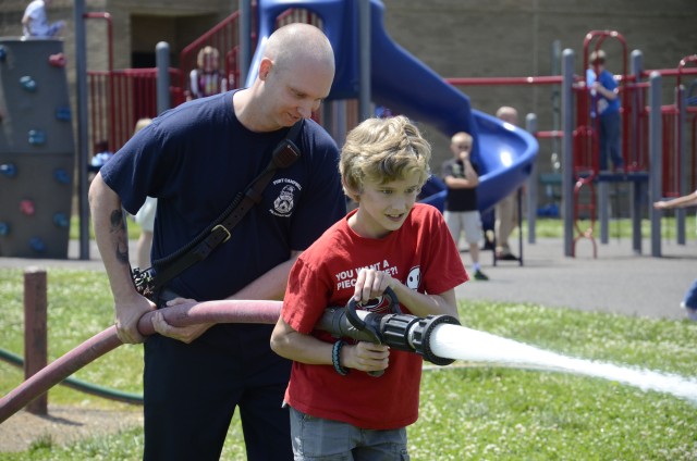 Student advances with fire hose