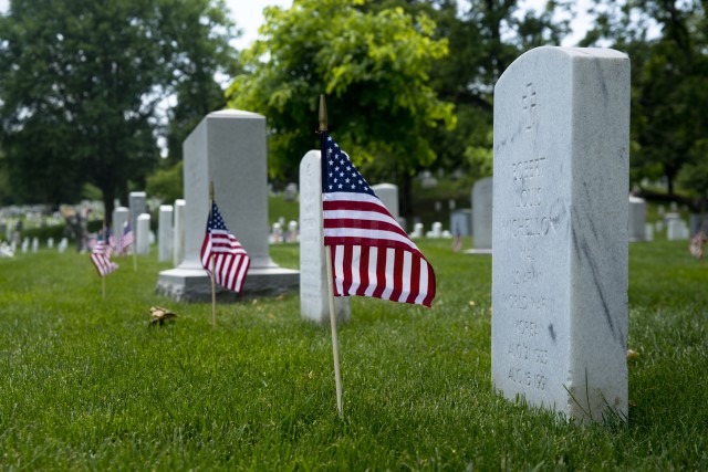 Old Guard Soldiers honor fallen with flags at Arlington graves