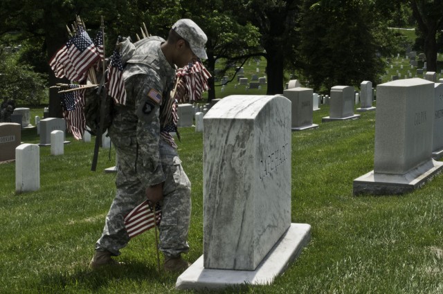 Old Guard Soldiers honor fallen with flags at Arlington graves