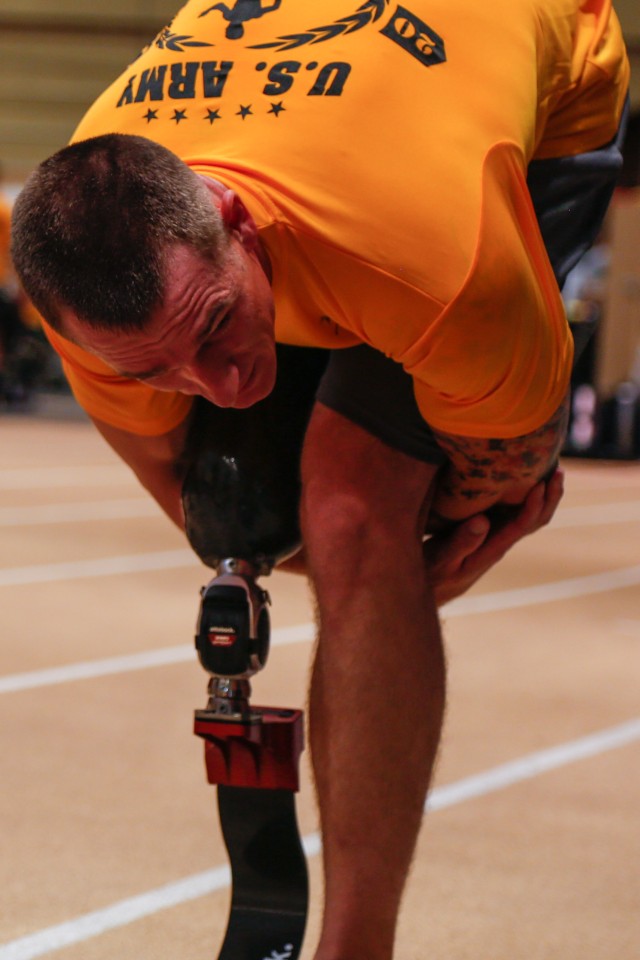 Army Staff Sgt. Allan Armstrong stretches prior to track practice for the 2014 U.S. Army Warrior Trials