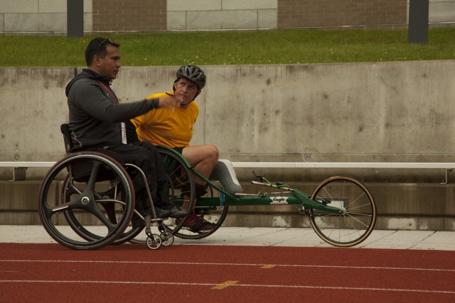 U.S. Army Master Sgt. Daniel Hendrix speaks with Coach Saul Mendoza during a cycling practice session for the 2014 Army Warrior Trials