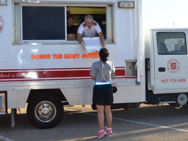Maj. Michael Morton, area commander of the Salvation Army of El Paso, holds out a box of doughnuts for Capt. Rosa Gutierrez, 3rd Battalion, 362nd Armor Regiment, 5th Armored Brigade, First Army Divisi