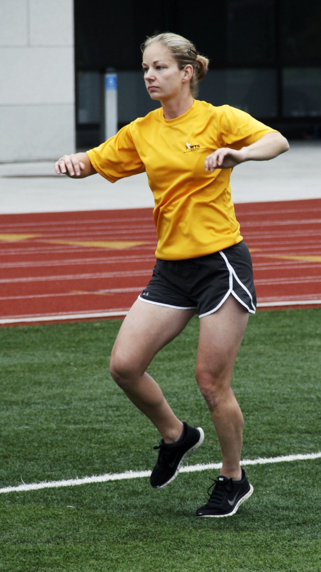 Sgt. First Class Goldstein, rotates her body in a dance exercise to warm up for the 2014 Army Warrior Trials