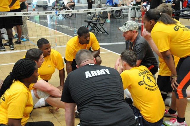 The Army Green team huddles during the sitting volleyball competition