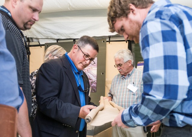 Industry representatives examine military textile material at NSRDEC Textile Industry event