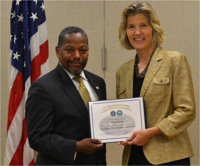 FBI Executive Assistant Director, Science and Technology, Amy Hess, presents Mr. H. Tracy Williams III, OPMG Chief of Staff, FBI National Executive Institute (NEI) Graduation Certificate