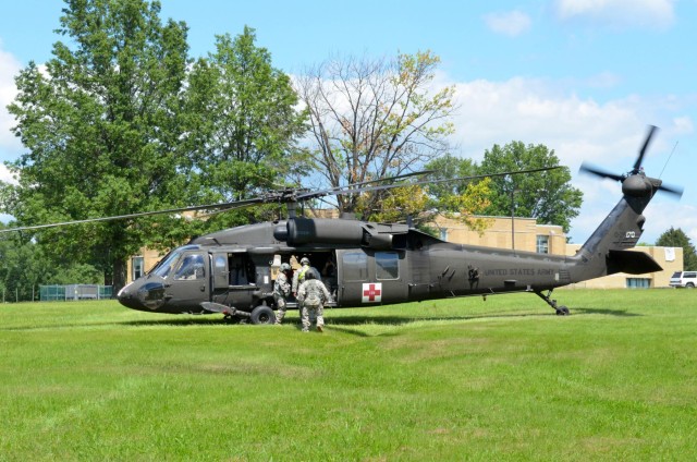 A flight medic directs the loading of a simulated patient during Vibrant Response 14.