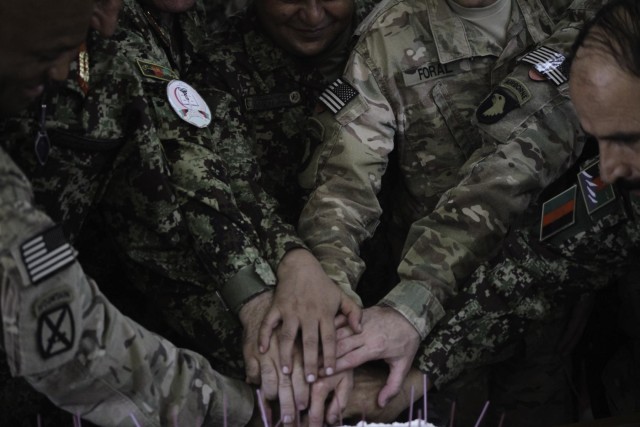 Leaders from the Afghan National Army's 201st Corps and the Train, Advise and Assist Command-Northeast show togetherness and cut a cake