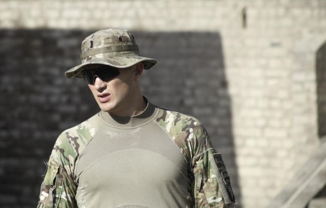 1st Lt. William H. Prosko looks on as his Soldiers discuss the upcoming mission