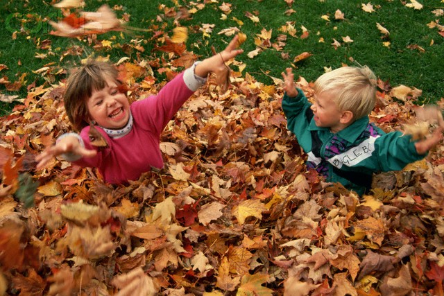 kids-playing-with-autumn-leaves