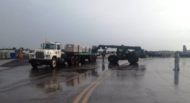 Soldiers from 688th RPOE load food and water onto trucks at Roberts International Airport, Liberia.