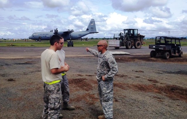 Army Maj. Matthew Rivera directs troops in unloading an Air Force C-17 cargo aircraft at Roberts International Airport, Liberia.