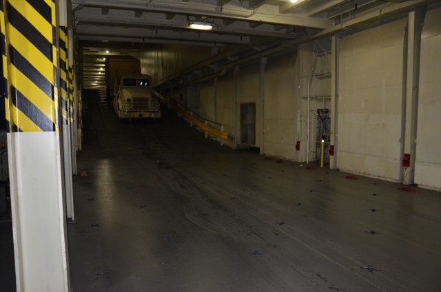 Truck and trailer making its way into the cargo area of USNS Watkins.
