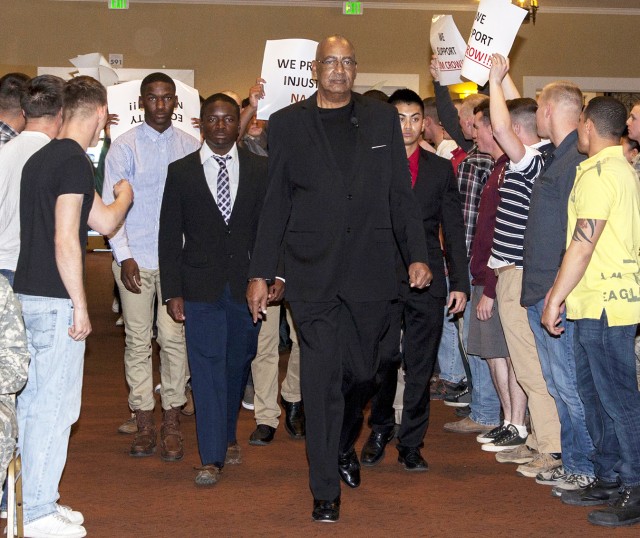 John Winkfield, director of the National Training Center Equal Employment Opportunity office, leads a reenactment of a Civil Rights march