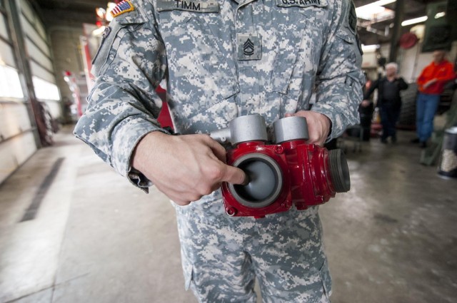 Opening the hose on Army fire truck maintenance