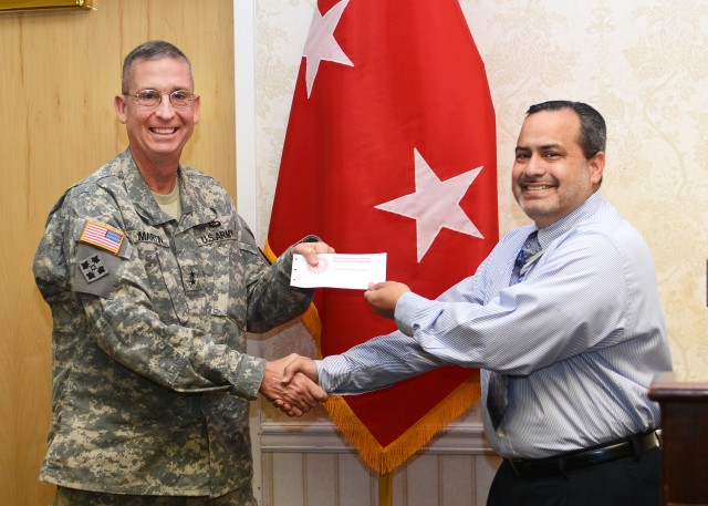 Maj. Gen. Ted Martin provides his contribution the Army Emergency Relief fund to Parrish Cruz, AER officer for Fort Irwin