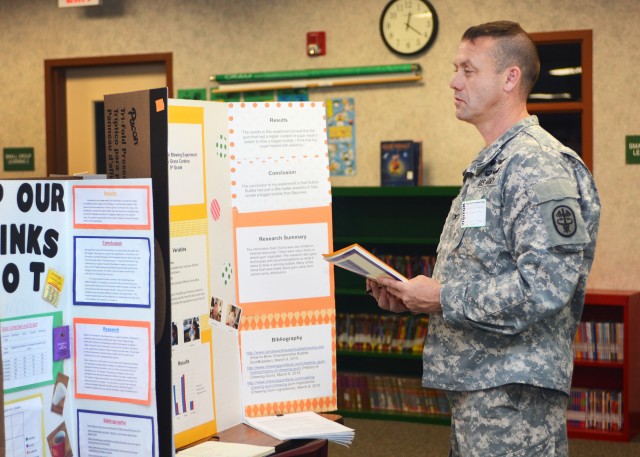 United States Army Medical Department Activity Commander Col. Jason Wieman judges a science fair project