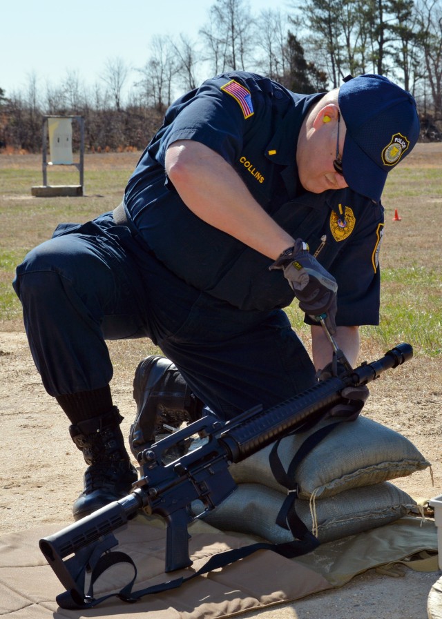 After firing several rounds, Fort A.P. Hill Department of the Army Police Lt. Carlos G. Collins adjusts the front sight on his M-16.