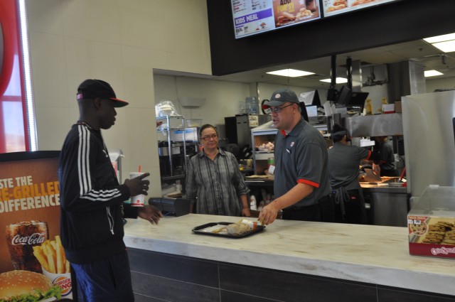 Fort Irwin Burger King employee serves customer after returning to work