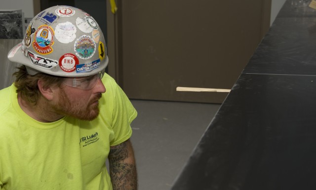 A carpenter checks a counter top gap during installation in a lab that can be used as a Biosafety Level 2 or 3 lab.