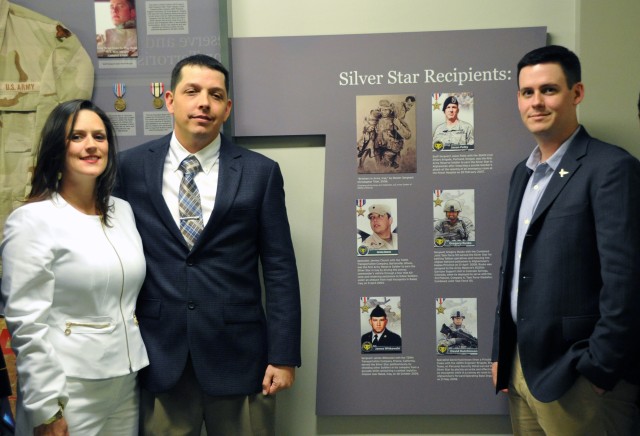 WASHINGTON, D.C. --Spc. (Ret.) Jeremy Church (center), his wife (left), and former Sgt. David Hutchinson (right), pose in front of the Silver Start recipient panel after the United States Army Reserve