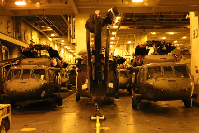 Helicopters are tightly packed into the hold of the USNS Mendonca.